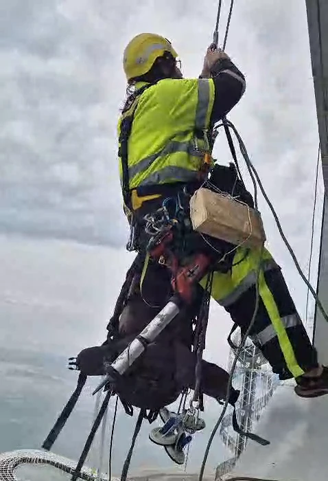 Industrial alpinist performing facade maintenance